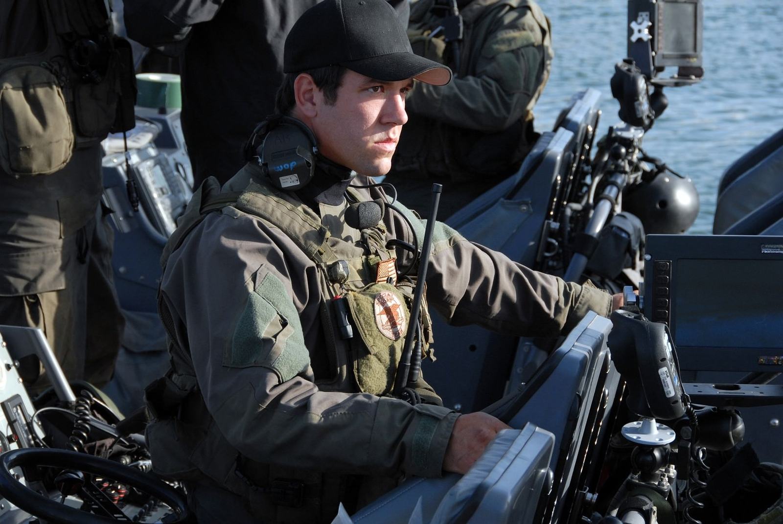 Two Naval Special Warfare operators working together aboard a combatant craft