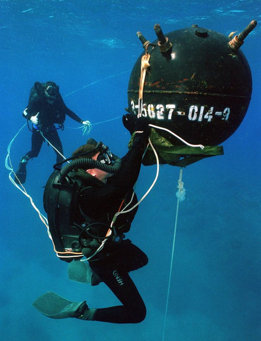 A diver working alongside underwater ordnance during a training task
