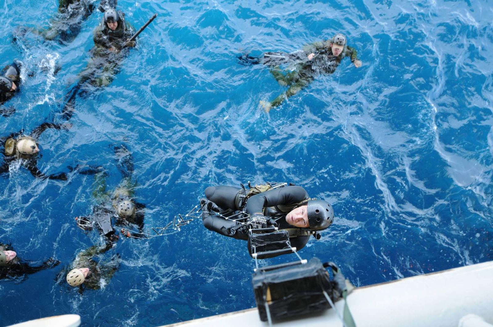 An aerial view of swimmers and a boat during a shipboarding approach