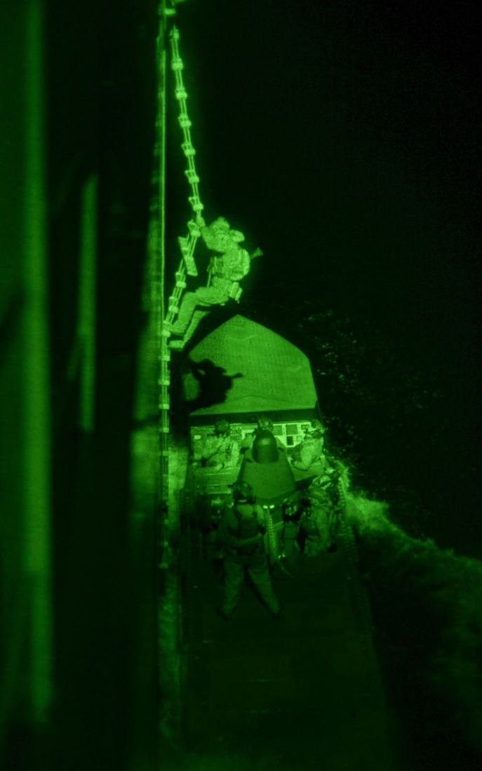A night vision view of an operator climbing during a night boarding