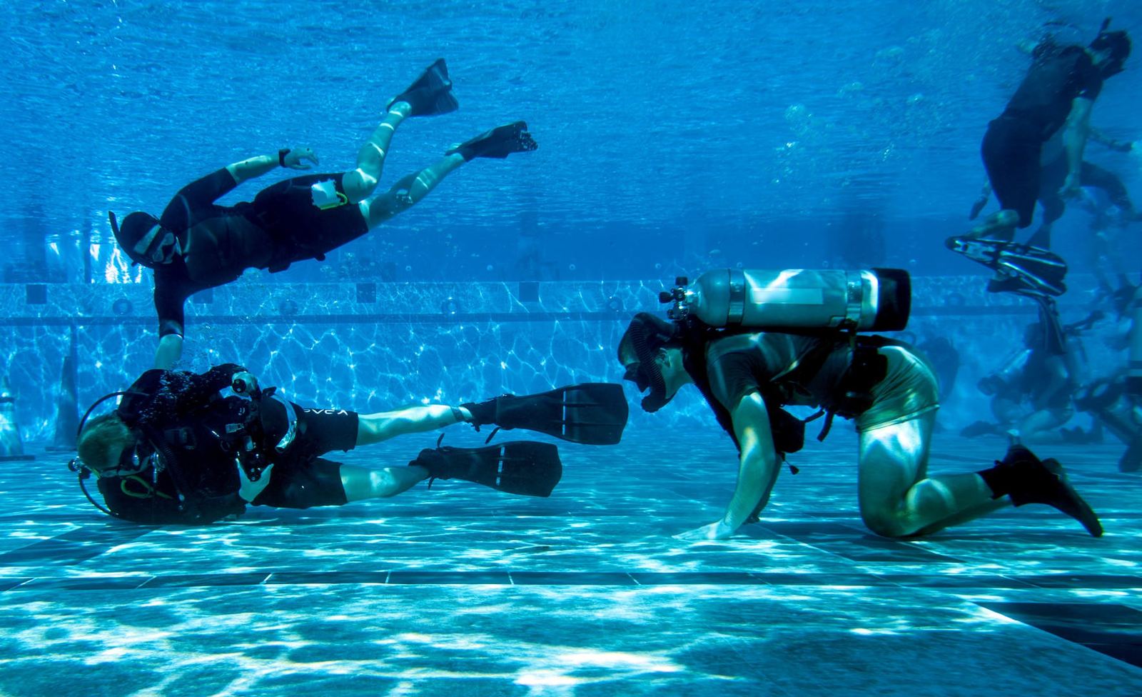 Divers working through a training evolution in a pool