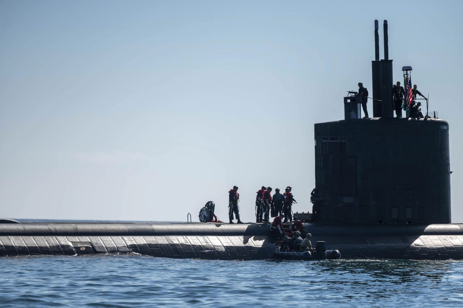 Sailors working topside on a submarine at sea