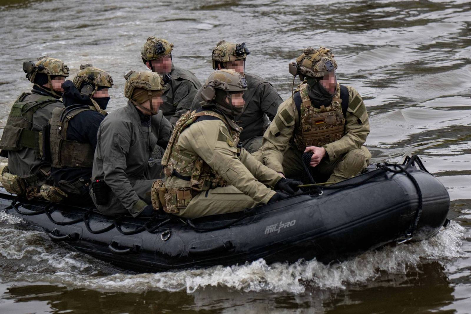 A Naval Special Warfare boat crew moving together in a combat rubber raiding craft